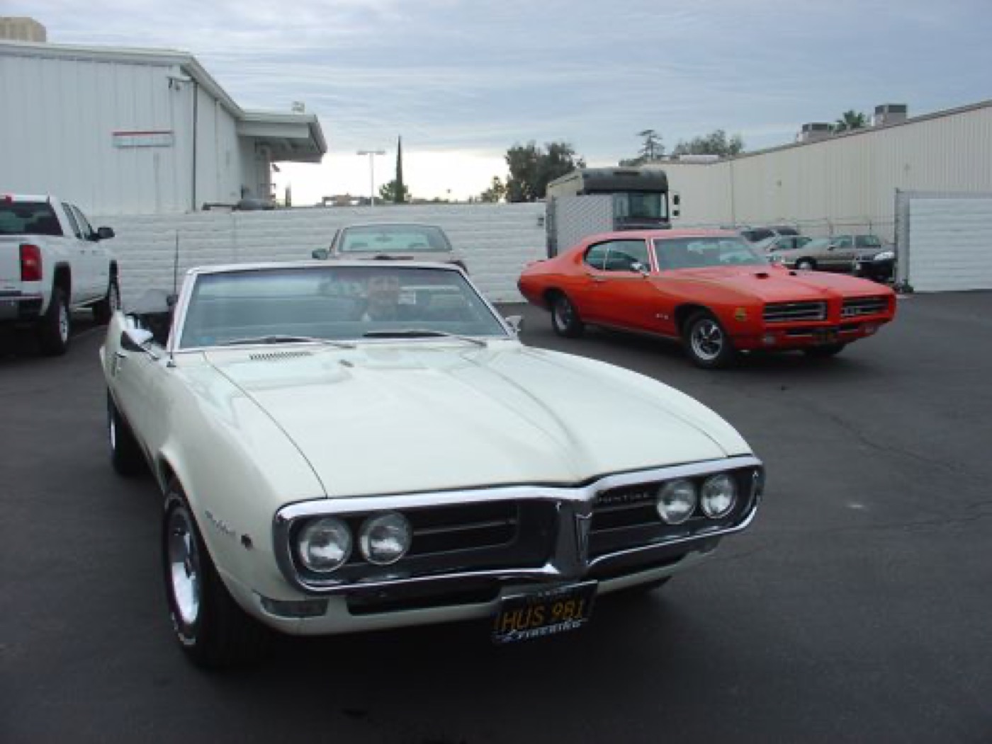 White Firebird and orange GTO outside together