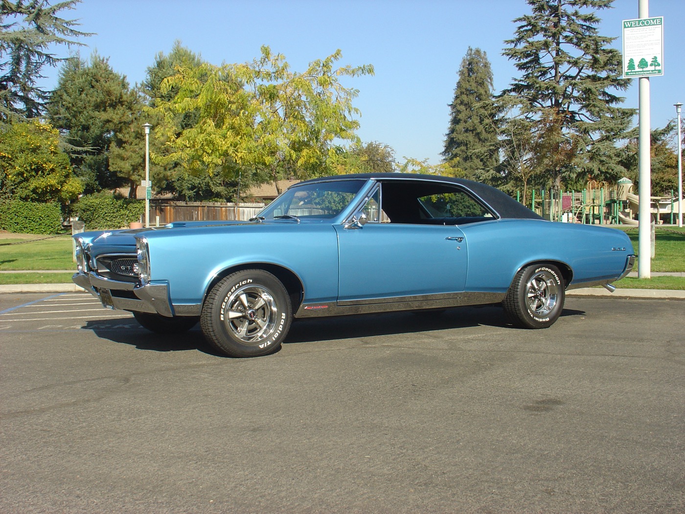 Classic blue Pontiac parked under autumn trees