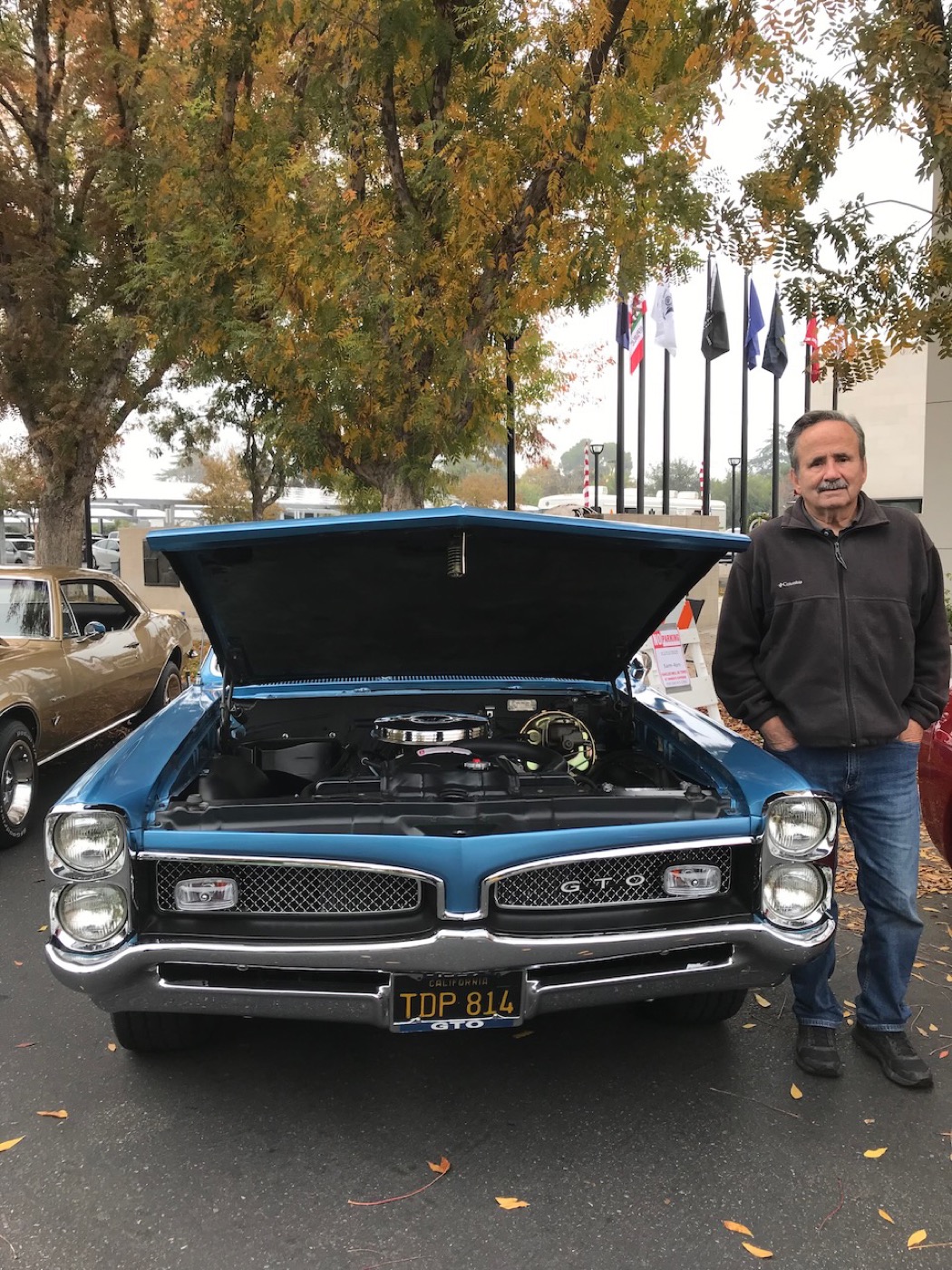 Proud owner with his blue GTO, hood up