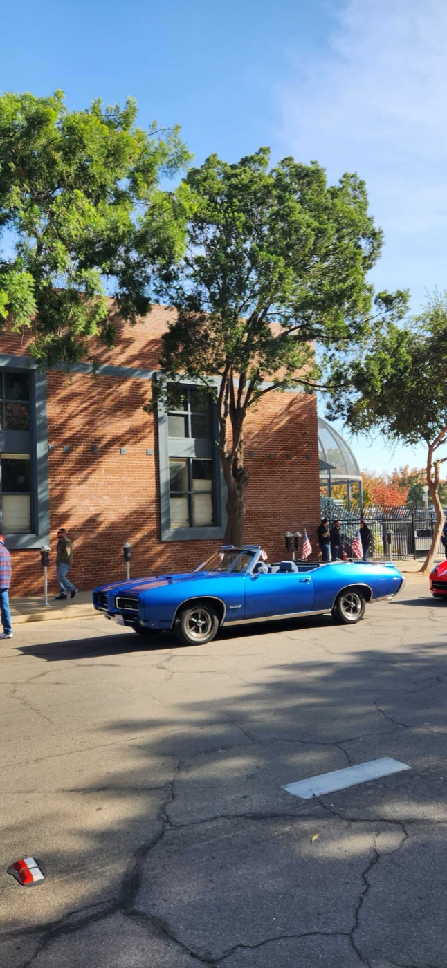 Blue convertible cruising the sunny parade route