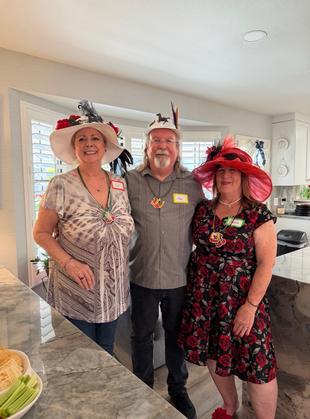 Three friends in festive Derby hats